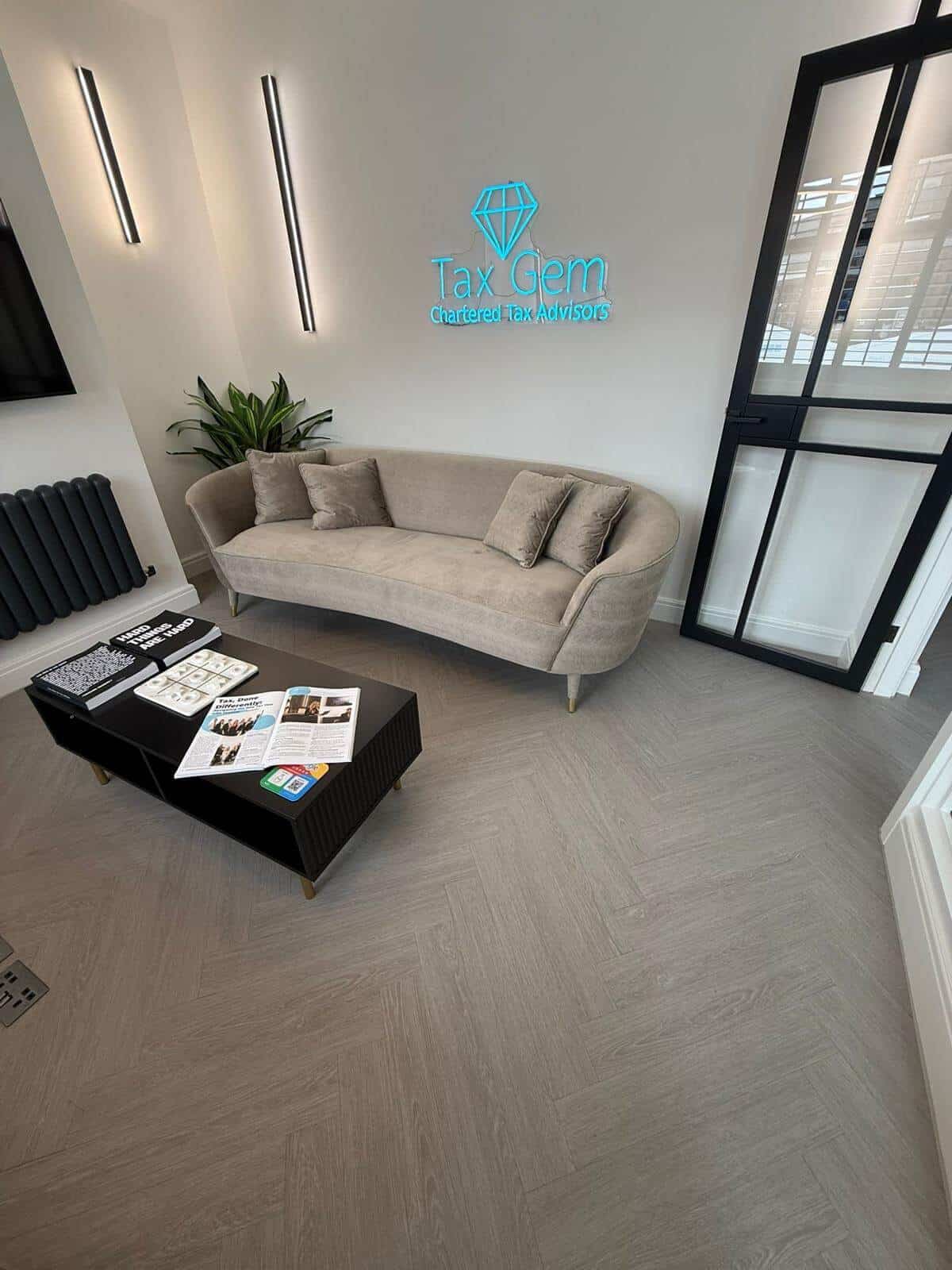 Light grey LVT herringbone flooring fitted in the modern reception area of Tax Gem by Banks Flooring Solutions