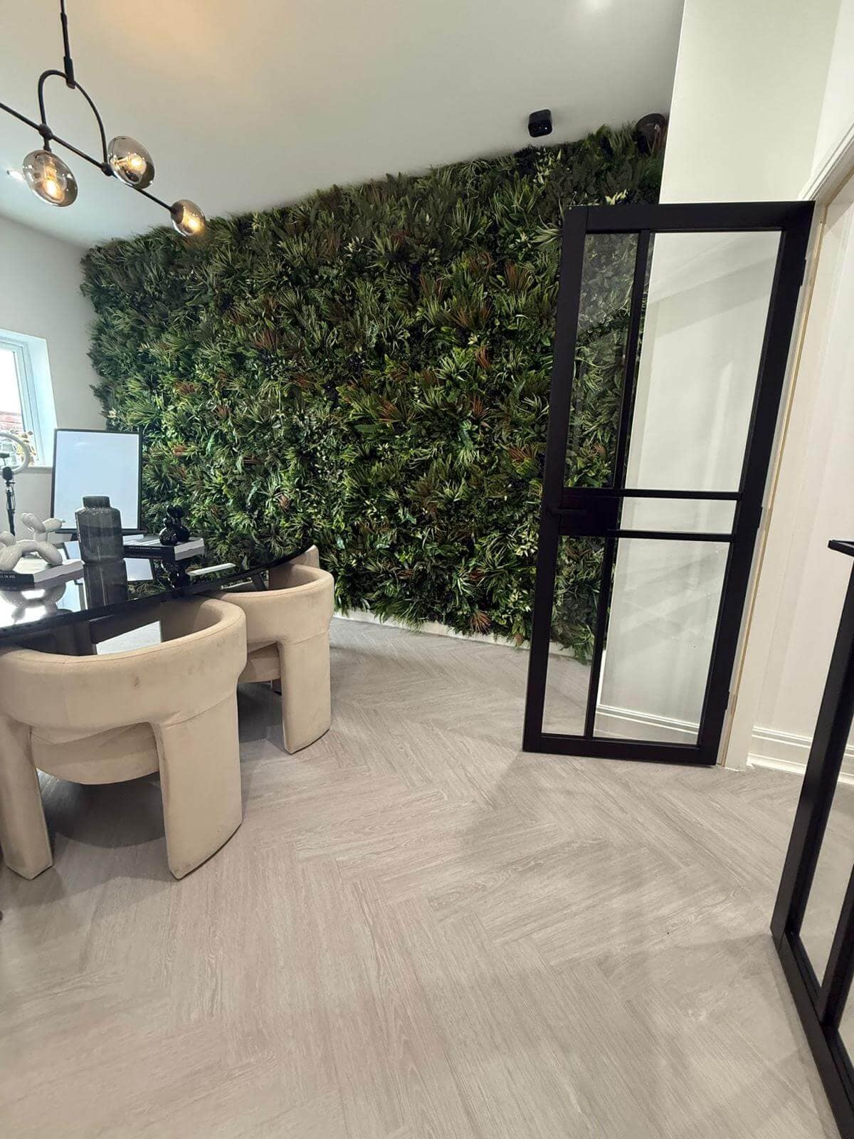 Stylish light grey LVT herringbone flooring installed in a modern office with green feature wall by Banks Flooring Solutions