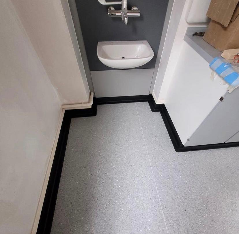 Hospital bathroom area with vinyl flooring in cap and cove method
